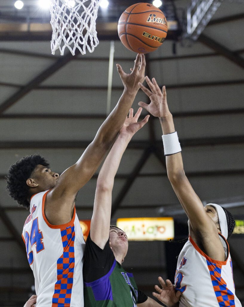 Edmonds-Woodway’s William Alseth and Rainier Beach’s Marques Ili-Meneese and Nyale Robinson reach up for a rebound during the 3A boys championship game on Saturday, March 8, 2025 in Tacoma, Washington. (Olivia Vanni / The Herald)
