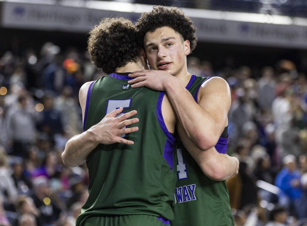 Edmonds-Woodway’s Julian Gray hugs his teammate Cam Hiatt after they both come out of the 3A boys championship game in the final minute on Saturday, March 8, 2025 in Tacoma, Washington. (Olivia Vanni / The Herald)
