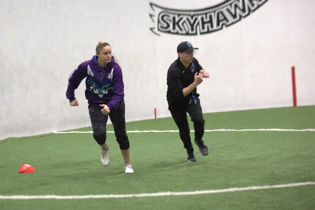 Wolfpack special teams coordinator Melissa Strothers (left) defensive coordinator Cole Stephens (right) participated during a drill at the Arena Football One team’s practice at Snohomish Sports Dome on Thursday, March 13, 2025. (Aaron Coe / The Herald)
