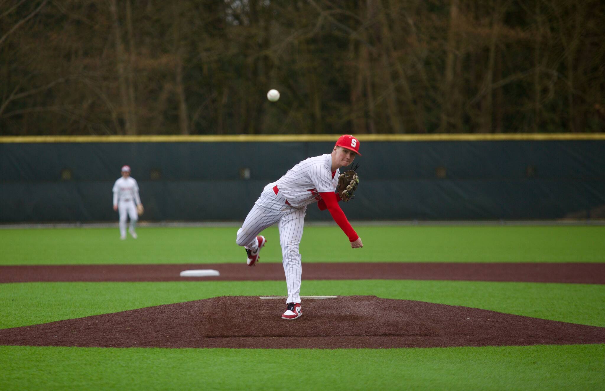 Stanwood senior Gavin Gehrman delivers a pitch during the Spartans’ 8-3 win against Arlington in Stanwood, Washington on March 19, 2025. (Joe Pohoryles / The Herald)