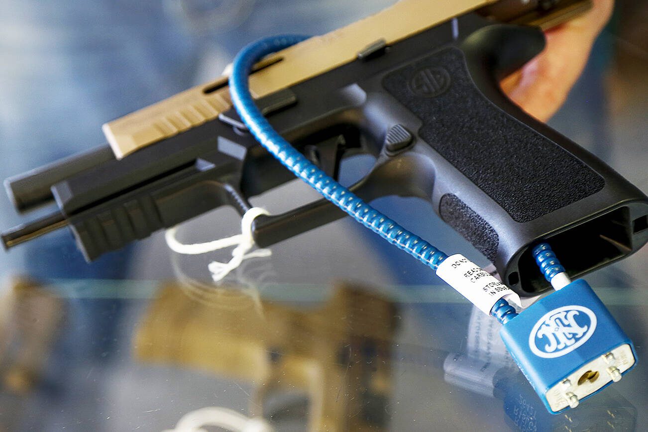 A semiautomatic handgun with a safety cable lock that prevents loading ammunition. (Dan Bates / The Herald)