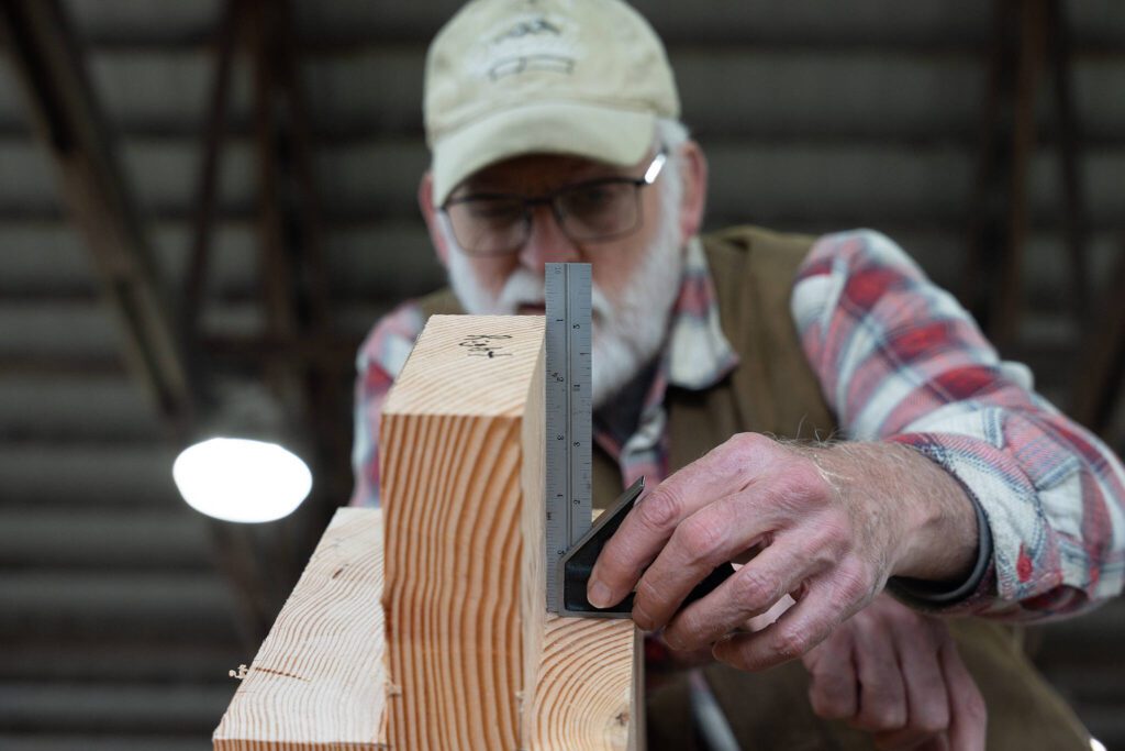 Bob Thomas measures a piece of wood on Wednesday, March 19 in Monroe, Washington. (Will Geschke / The Herald)
