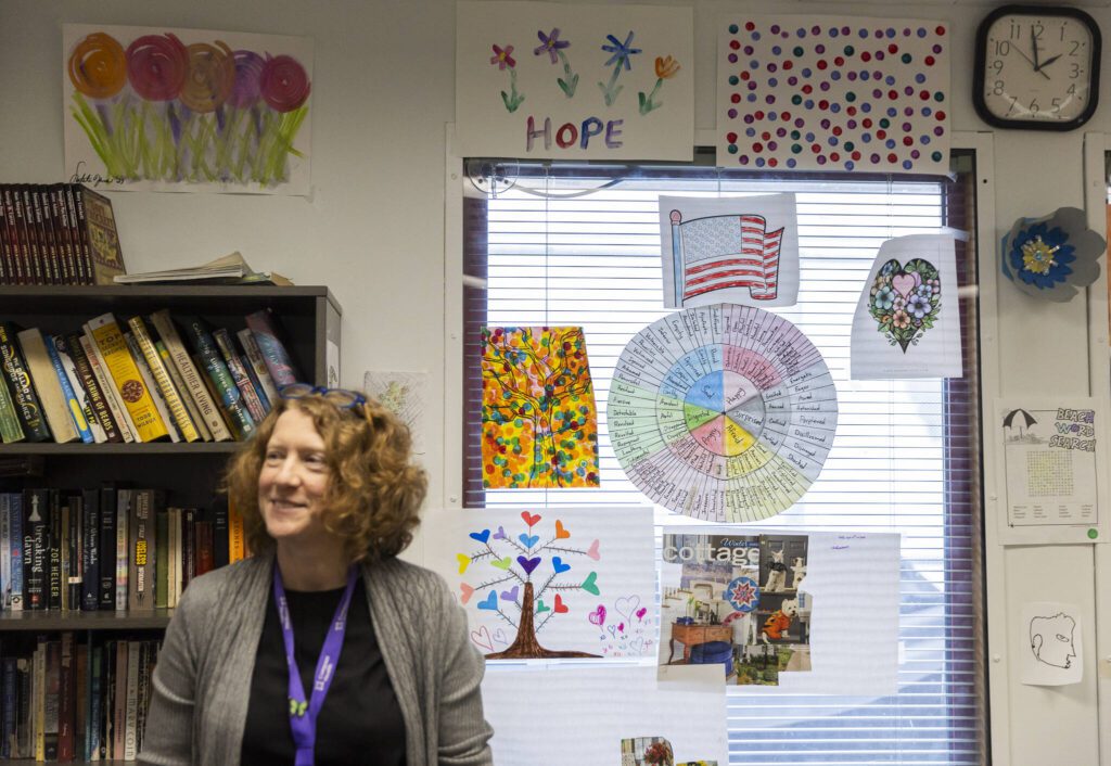 Dr. Katie Gilligan, the chief medical officer at Compass Health who oversees the treatment center in Mukilteo, stands in the facilities multi-purpose room covered in artwork on Monday, March 24, 2025 in Mukilteo, Washington. (Olivia Vanni / The Herald)
