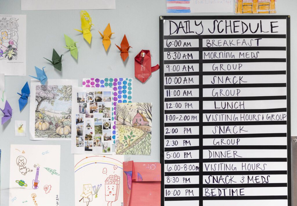 Artwork and a daily schedule hang on the wall inside the Mukilteo Evaluation and Treatment Center on Monday, March 24, 2025 in Mukilteo, Washington. (Olivia Vanni / The Herald)
