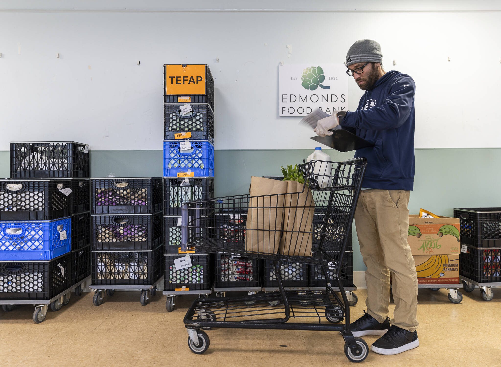 Lester Almanza, programs manager at the Edmonds Food Bank, puts together a custom shoppers order on Wednesday, March 26, 2025 in Edmonds, Washington. (Olivia Vanni / The Herald)