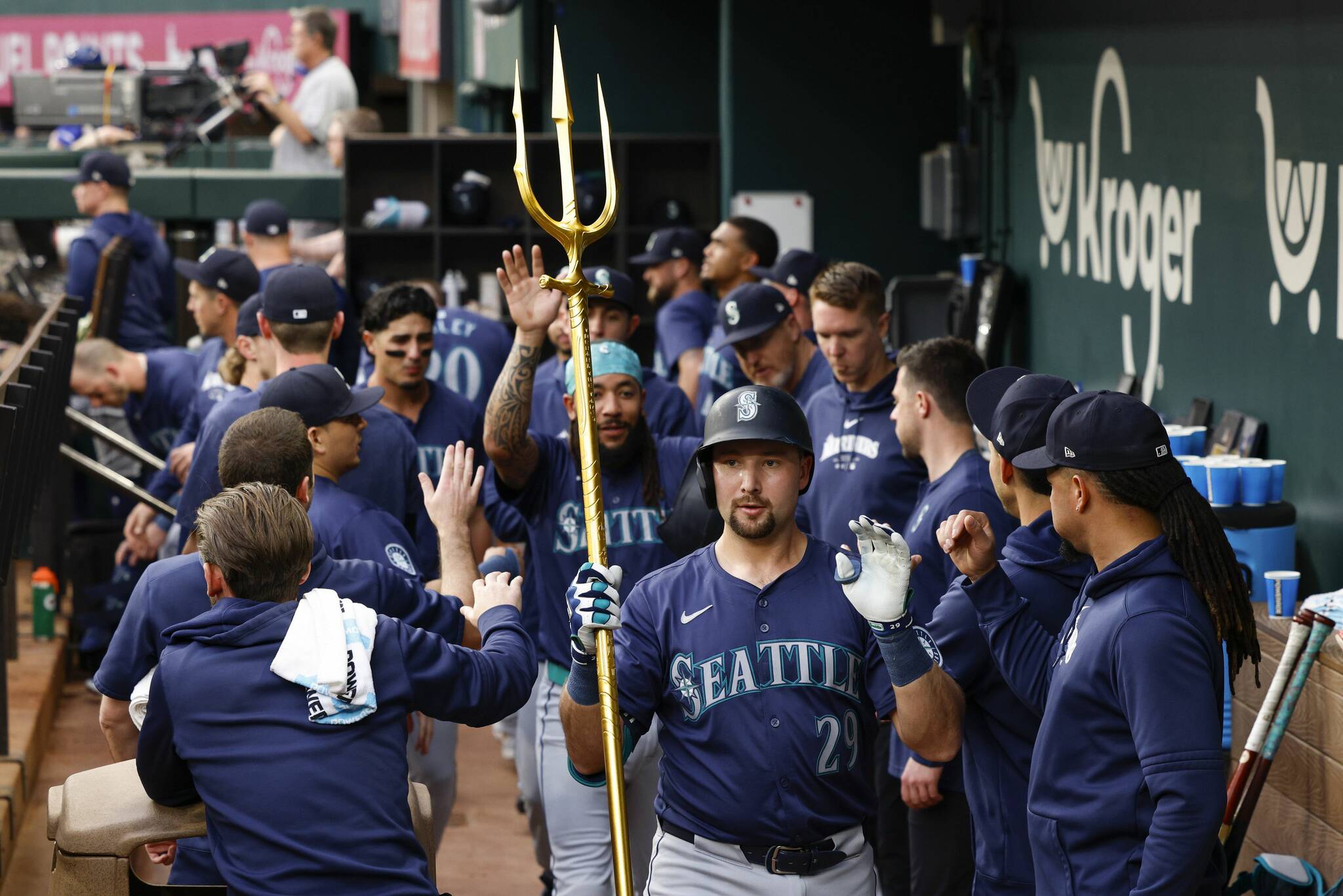 Seattle Mariners catcher Cal Raleigh (29) celebrates his two-run home run with a trident as he high fives teammates during the first inning against the Texas Rangers, Tuesday, April 23, 2024, in Arlington, Texas. (Elías Valverde II / Tribune News Services)