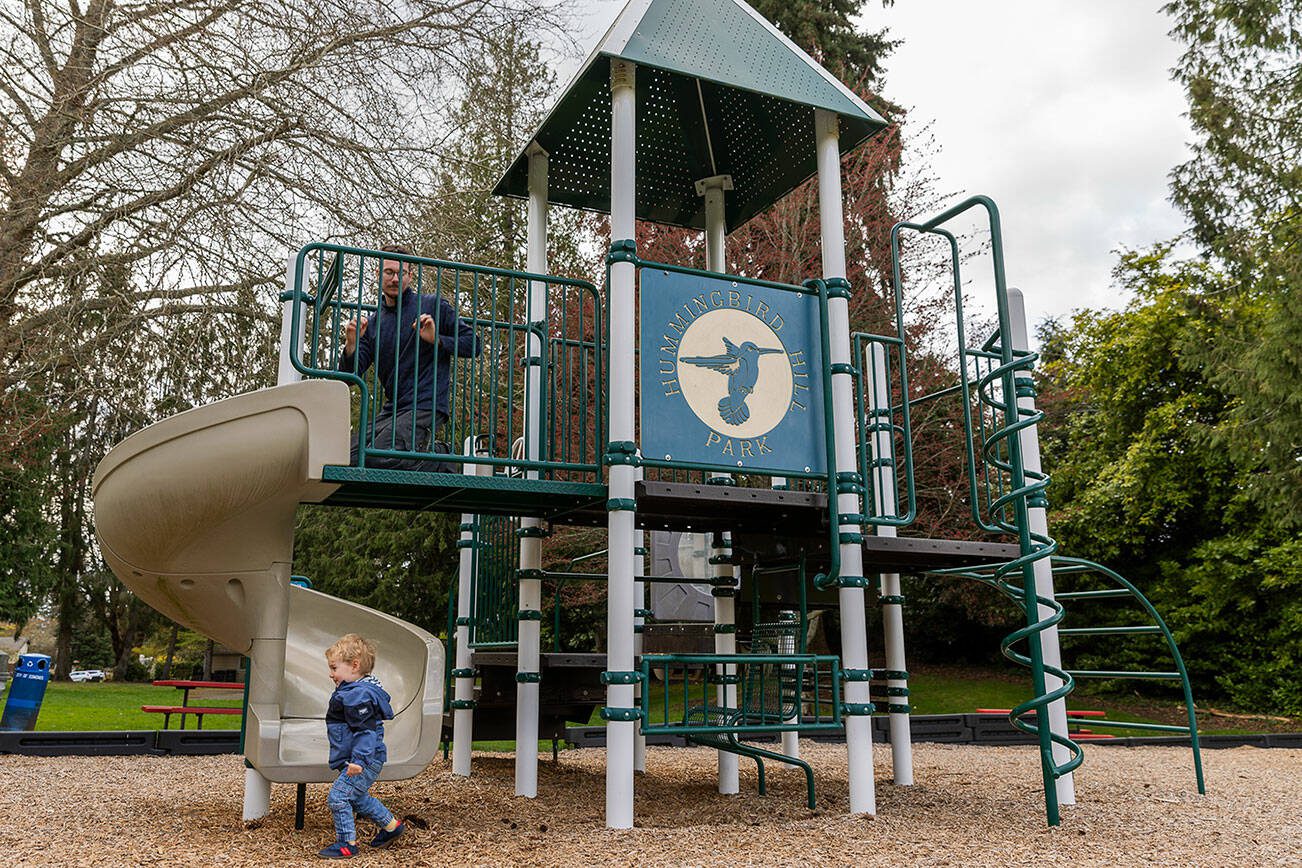 Richie Gabriel, 1, jumps off the bottom of the slide as Matthew Gabriel looks down at him from the play structure at Hummingbird Hill Park on Monday, March 31, 2025 in Edmonds, Washington. (Olivia Vanni / The Herald)