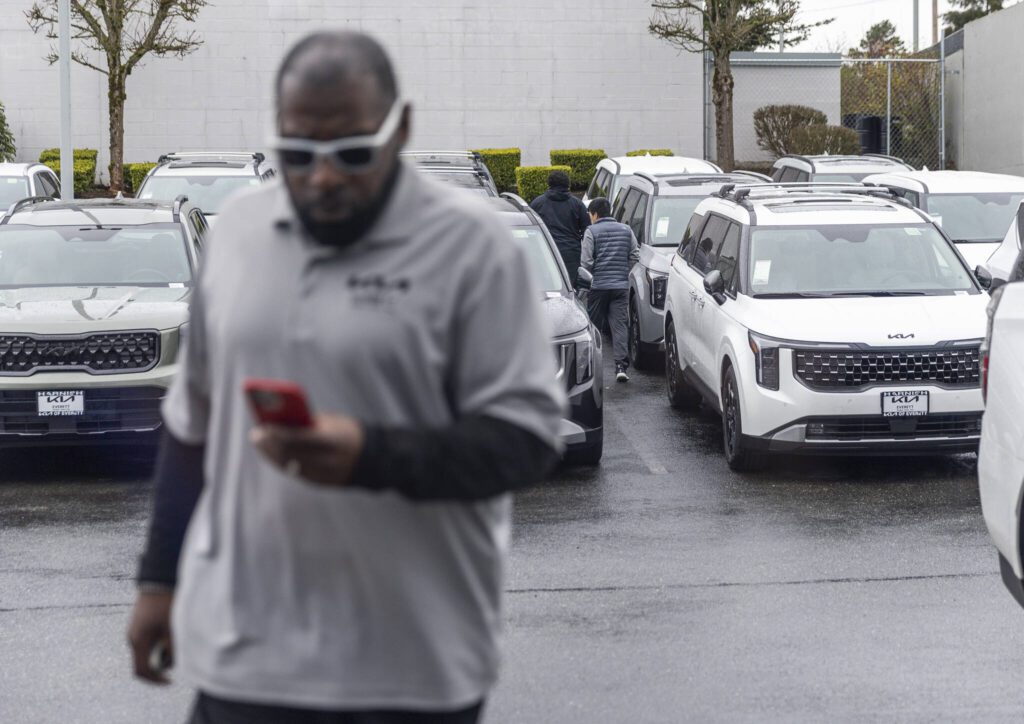 People browse cars in the lot at Kia of Everett on Tuesday, April 1, 2025 in Everett, Washington. (Olivia Vanni / The Herald)
