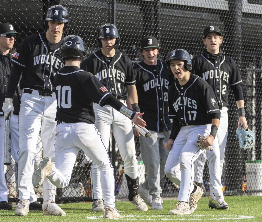 Jackson players celebrate teammate MJ Holcomb scoring during the game against Edmonds-Woodway on Wednesday, April 2, 2025 in Edmonds, Washington. (Olivia Vanni / The Herald)
