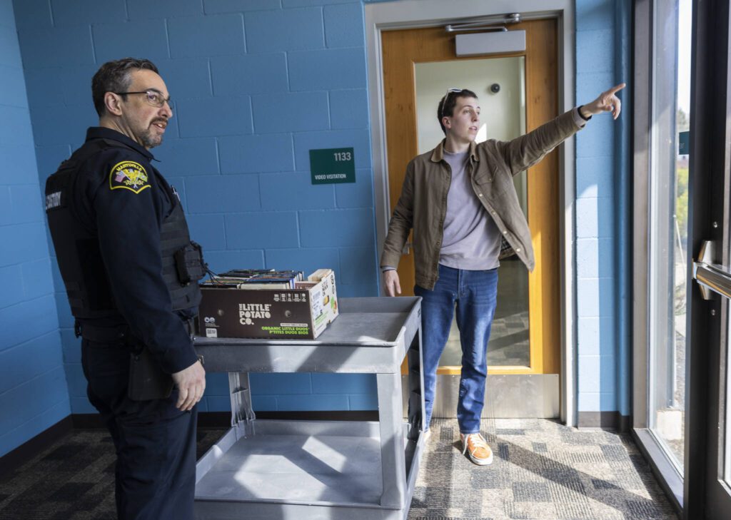 Bryson Fico, right, and custody officer Jason Morton grab a cart to carry Fico’s book donations on Saturday, April 5, 2025, in Marysville, Washington. (Olivia Vanni / The Herald)
