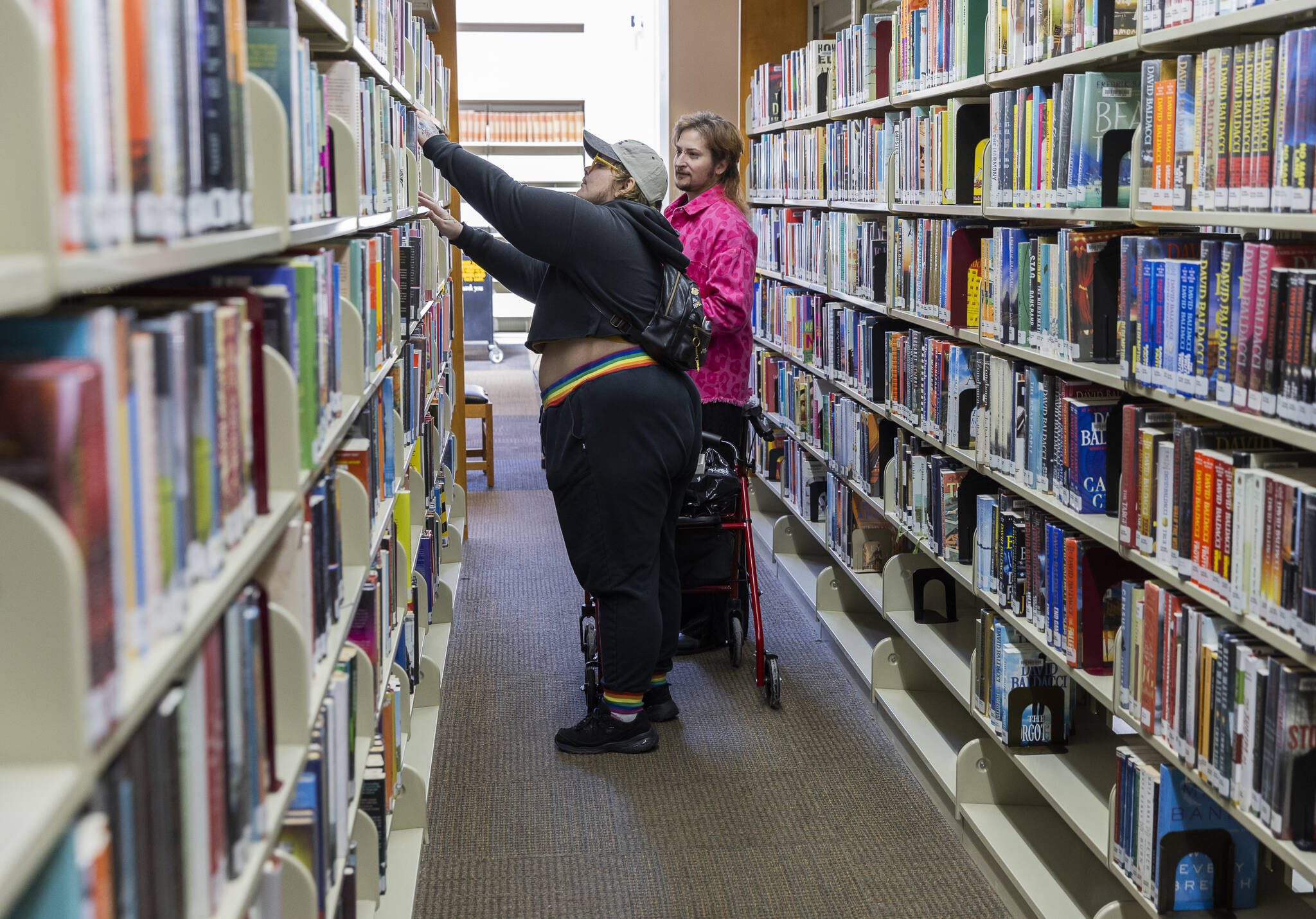 Ash Roberts, left, and Wryly T McCutchen, right, browse for book at the Everett Public Library on Thursday, April 3, 2025, in Everett, Washington. (Olivia Vanni / The Herald)