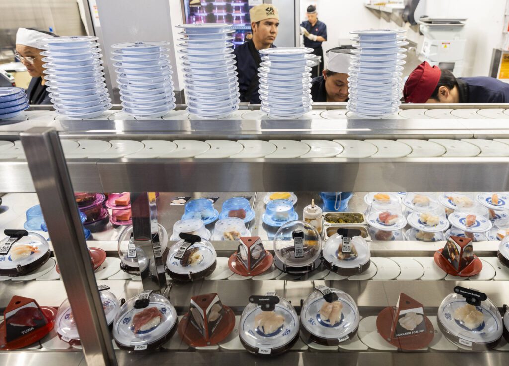 Kura Revolving Sushi Bar staff work on assembling different conveyor belt food options on Monday, April 7, 2025 in Lynnwood, Washington. (Olivia Vanni / The Herald)
