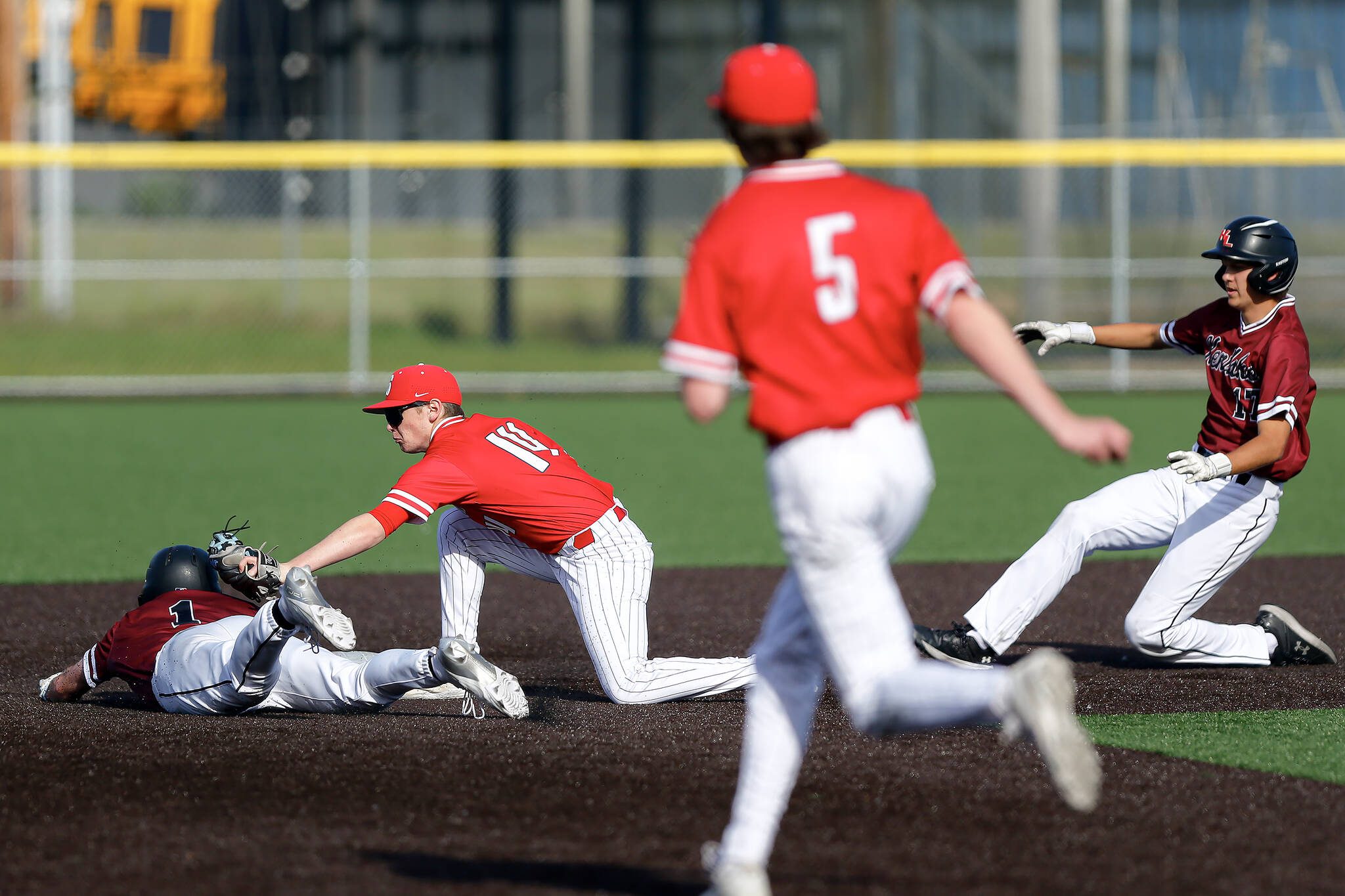 Stanwood sophomore Tanner Requa tags out the lead runner after getting him in a pickle during a playoff loss to Kentlake on Tuesday, May 14, 2024, at Kent Meridian High School in Kent, Washington. (Ryan Berry / The Herald)