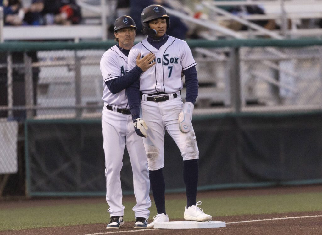 Everett AquaSox outfielder Tai Peete talks with AquaSox manger Zach Vincej on third base during the Opening Day game against the Hillsboro Hops on Tuesday, April 8, 2025 in Everett, Washington. (Olivia Vanni / The Herald)
