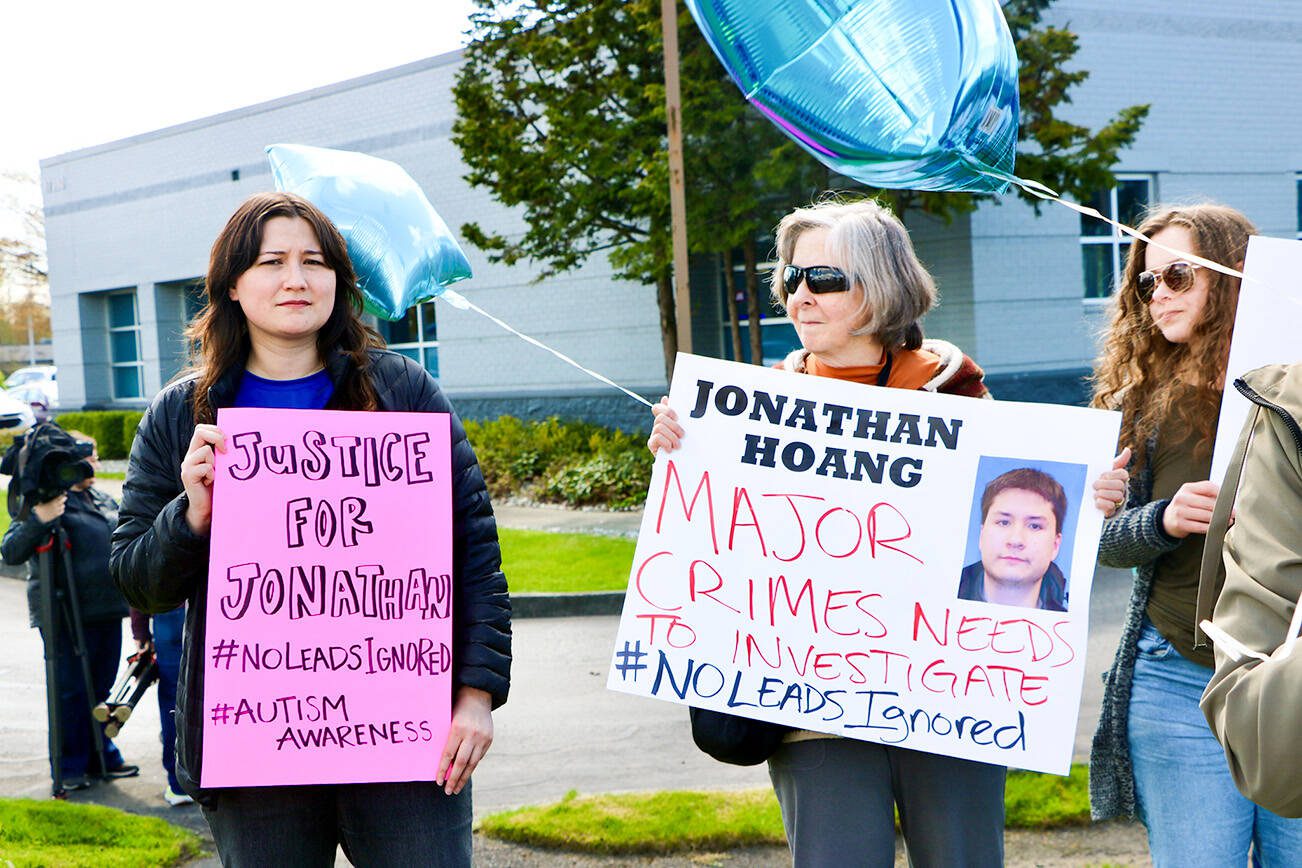 Irene Pfister, left, holds a sign reading “Justice for Jonathan” next to another protester with a sign that says “Major Crimes Needs to Investigate,” during a call to action Saturday, April 12, 2025, in Arlington. (Aspen Anderson / The Herald)
