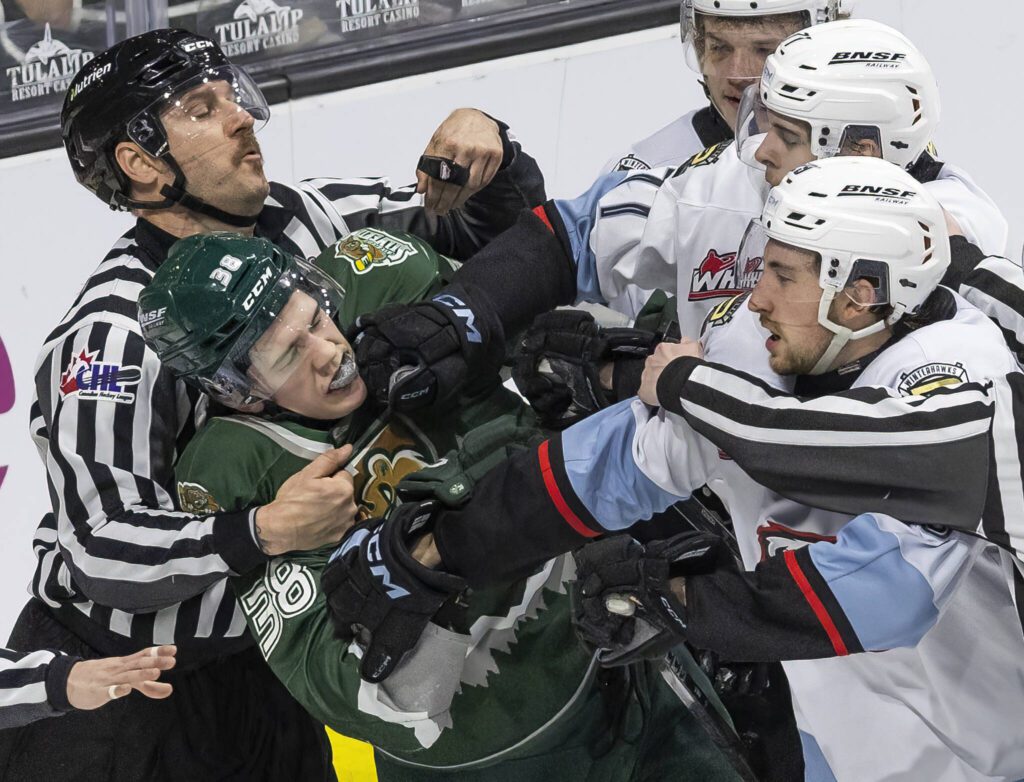 Multiple Portland Winterhawk players grab the jersey of Everett Silvertips’ forward Shea Busch during the second round WHL playoff game on Friday, April 11, 2025 in Everett, Washington. (Olivia Vanni / The Herald)

