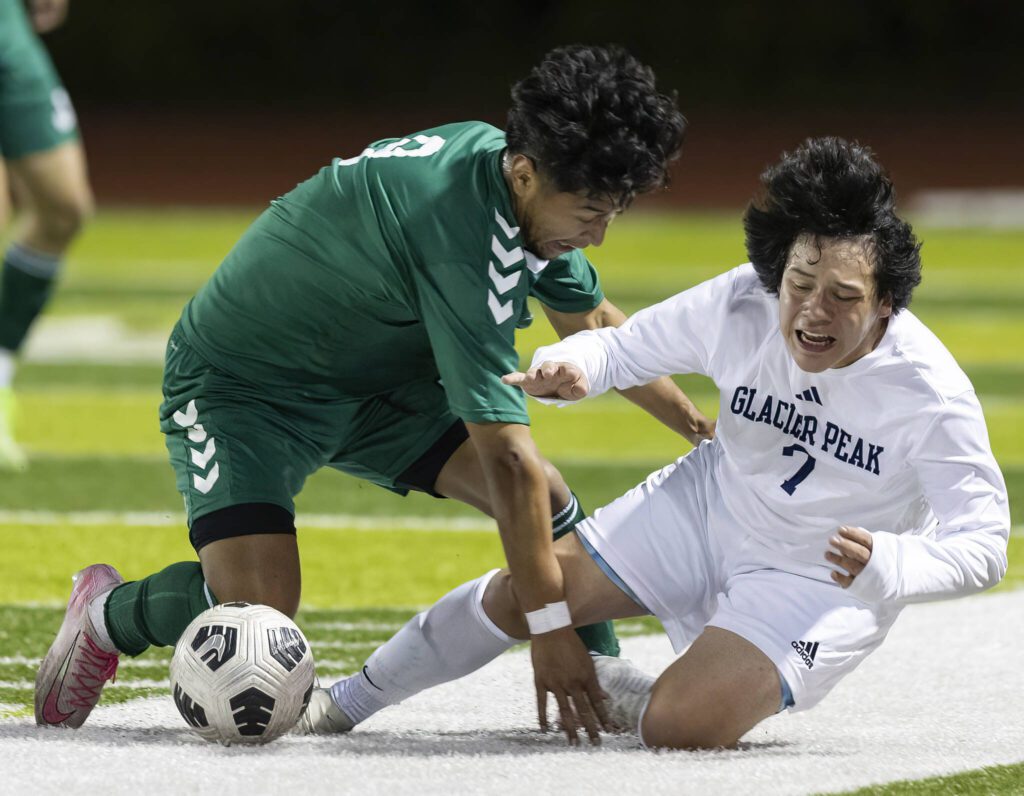 Jackson’s Anthony Gonzales-Marroquin and Glacier Peak’s Eder Ibarra Robledo tumble to the ground while running after the ball during the game on Tuesday, April 15, 2025 in Everett, Washington. (Olivia Vanni / The Herald)
