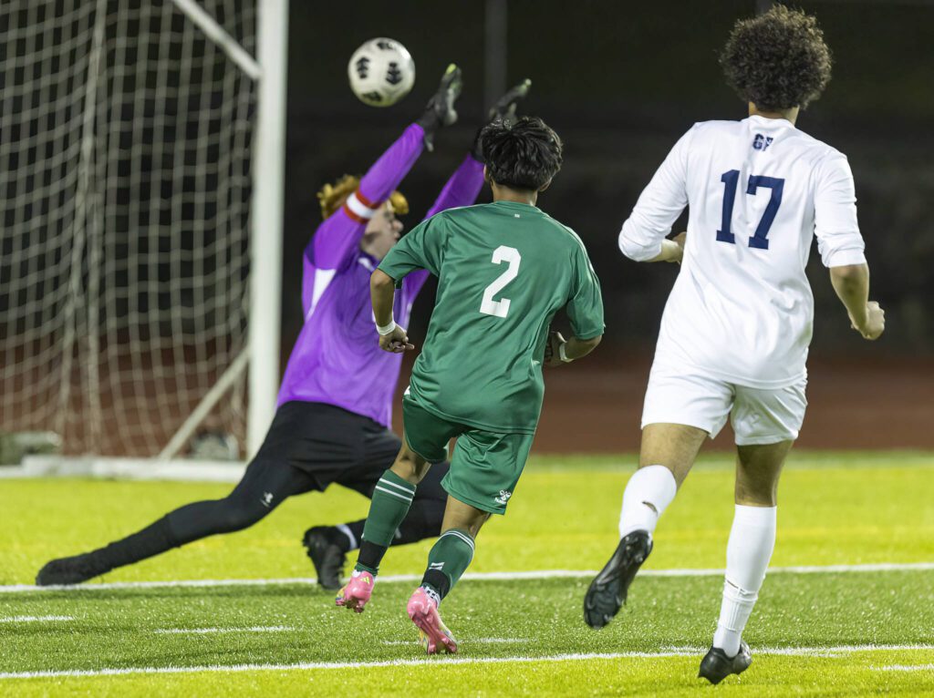 Jackson’s Isaiah Natividad shot clears the outstretched hands of Glacier Peak’s Aiden Larsen to score during the game on Tuesday, April 15, 2025 in Everett, Washington. (Olivia Vanni / The Herald)
