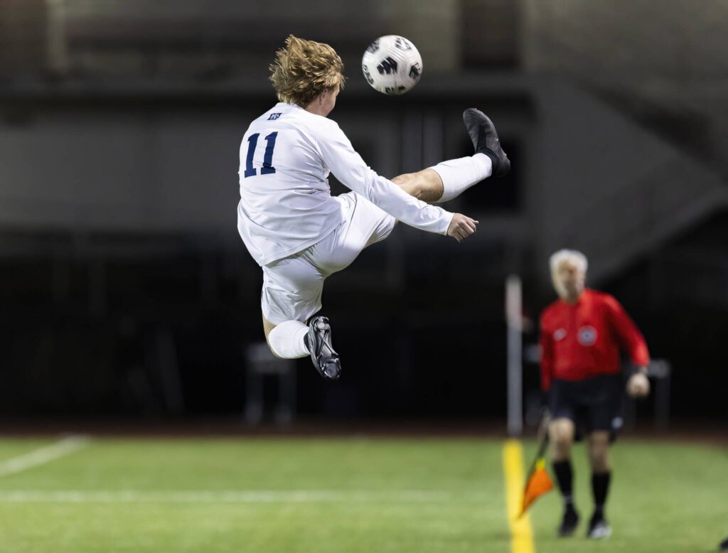Glacier Peak’s Luke Fullerton leaps in the air to stop the ball from going out of bounds during the game against Jackson on Tuesday, April 15, 2025 in Everett, Washington. (Olivia Vanni / The Herald)
