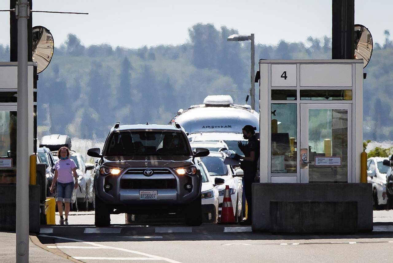 A Canada Border Services Agency officer speaks to a motorist entering Canada at the Douglas-Peace Arch border crossing, in Surrey, B.C., on Monday, August 9, 2021. THE CANADIAN PRESS/Darryl Dyck