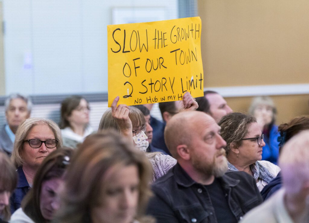 A person holds a sign in protest of the proposed Medical District Expansion near Swedish Edmonds on Monday, April 21, 2025 in Edmonds, Washington. (Olivia Vanni / The Herald)
