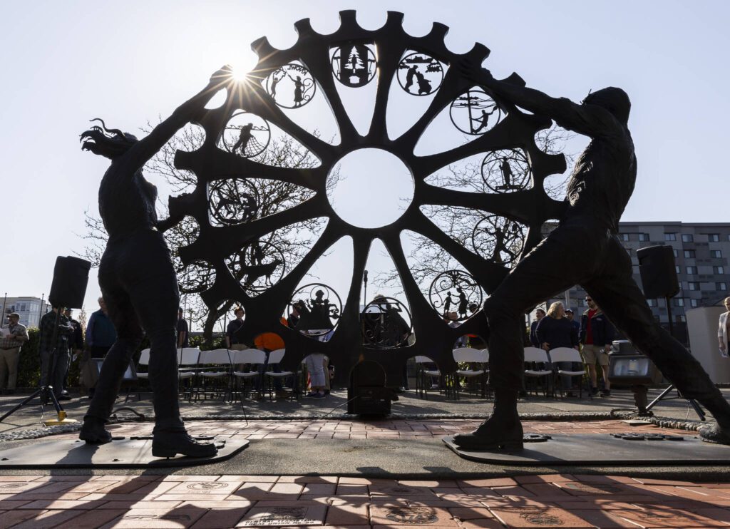 The sun shines through a memorial statue during a ceremony on Worker’s Memorial Day on Wednesday, April 23, 2025 in Everett, Washington. (Olivia Vanni / The Herald)
