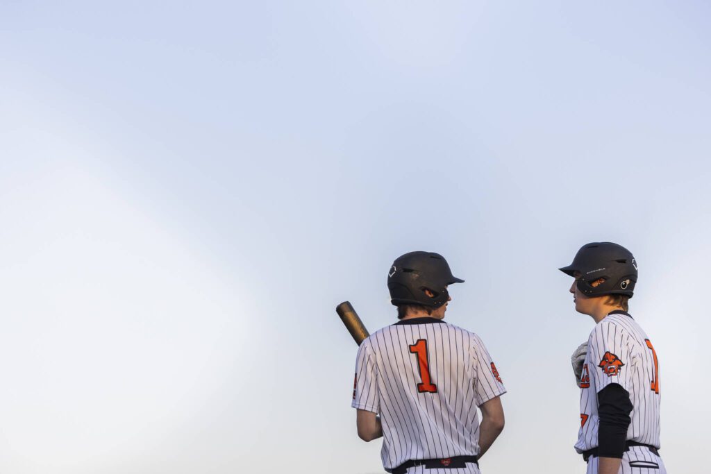 Monroe’s Caleb Campbell talks with teammate AJ Welch before stepping up to bat during the game against Everett on Wednesday, April 23, 2025 in Monroe, Washington. (Olivia Vanni / The Herald)
