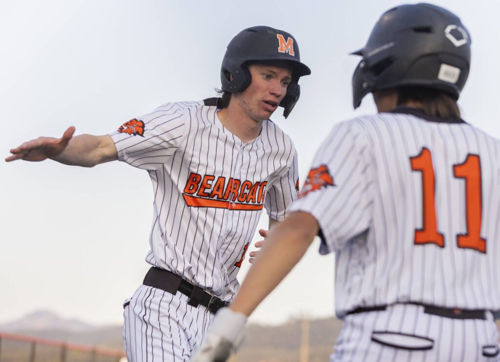 Monroe’s Caleb Campbell high-fives his teammate Mike Enrico after scoring during the game against Everett on Wednesday, April 23, 2025 in Monroe, Washington. (Olivia Vanni / The Herald)
