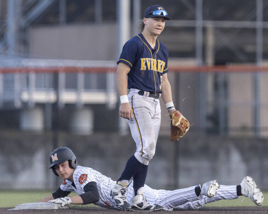 Everett’s Mac Larsen spits in frustration due to a fielding error as Monroe’s AJ Welch slide safely into second base during the game on Wednesday, April 23, 2025 in Monroe, Washington. (Olivia Vanni / The Herald)
