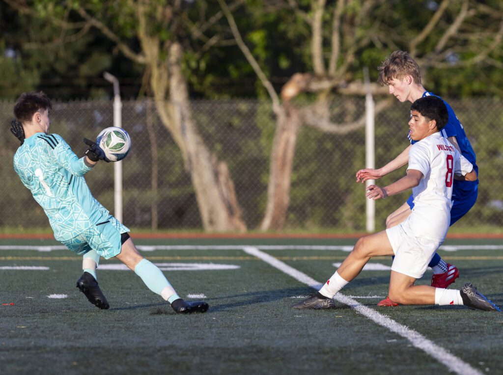Shorewood’s Ivan Genadiev gets a hand on the ball shot by Archbishop Murphy’s Jason Angel during the game on Wednesday, April 30, 2025 in Shoreline, Washington. (Olivia Vanni / The Herald)
