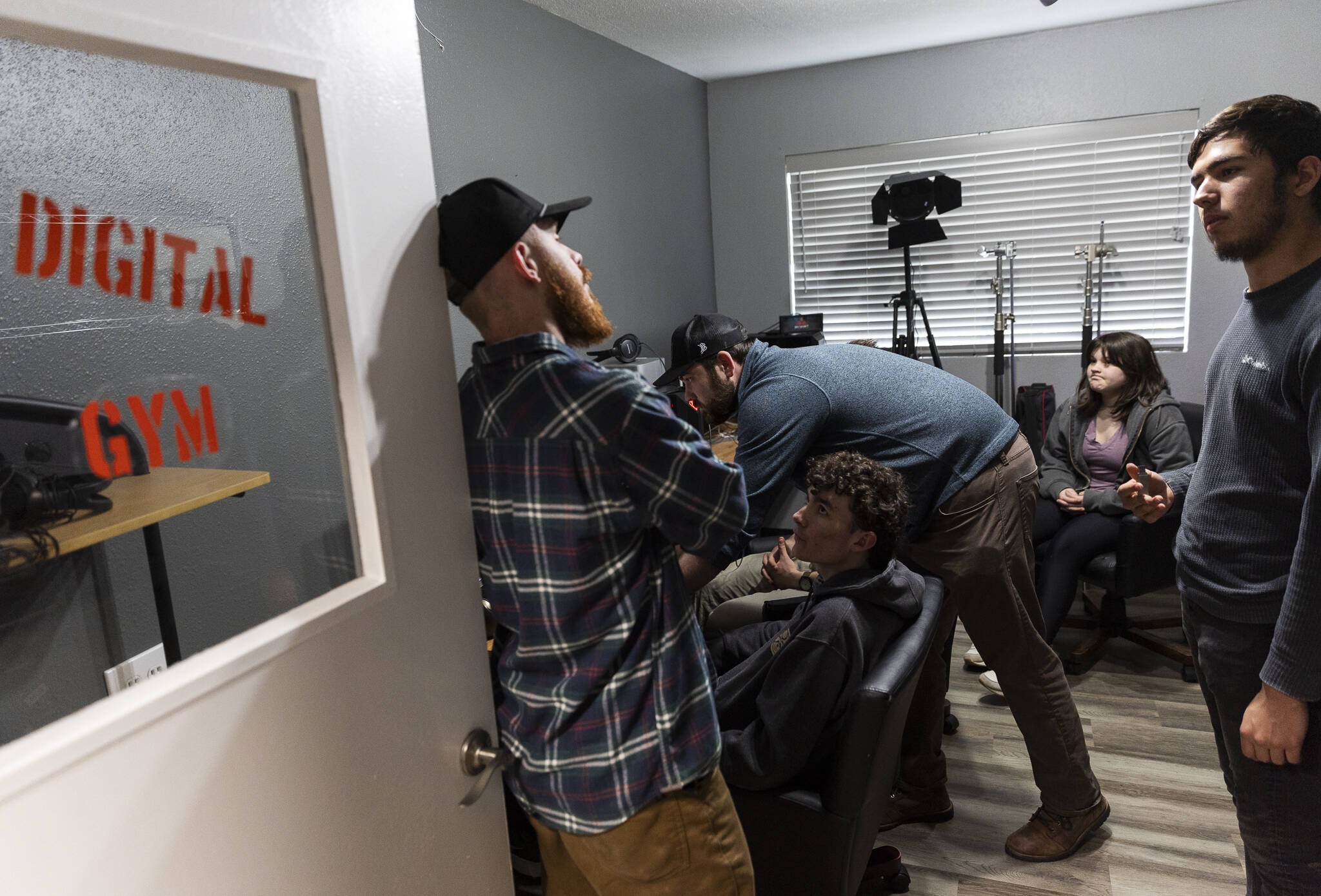 Jonathon DeYonker, left, talks with students gathered at The Teen Storytellers Project to work on syncing audio for their documentary footage on Tuesday, April 29, 2025 in Everett, Washington. (Olivia Vanni / The Herald)