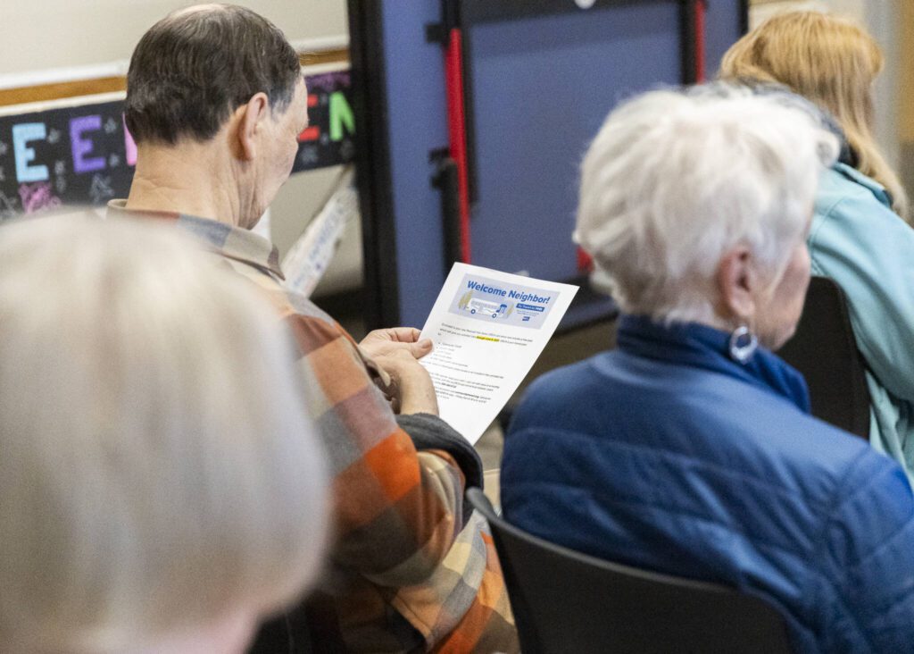 A person reads through a flyer during a presentation for seniors on how to ride local buses held at the Everett YMCA on Wednesday, April 30, 2025 in Everett, Washington. (Olivia Vanni / The Herald)
