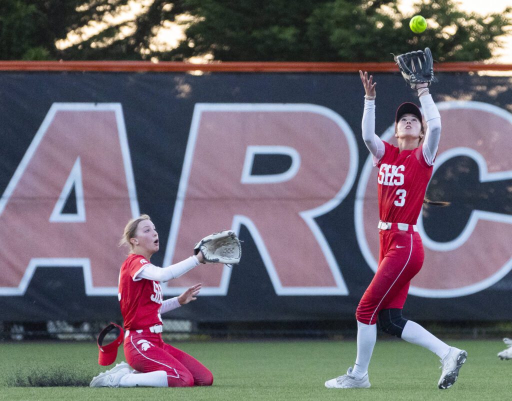 Stanwood’s Olivia Dahl slides into back up teammate Rubi Lopez as she makes a catch during the game against Monroe on Thursday, May 1, 2025 in Monroe, Washington. (Olivia Vanni / The Herald)
