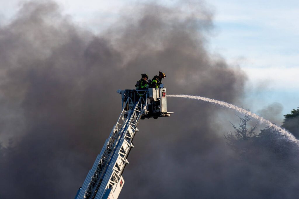 Firefighters spray water from a ladder truck onto a self-storage facility on Monday, May 5, 2025, in Everett, Washington. (Aaron Kennedy / The Herald)
