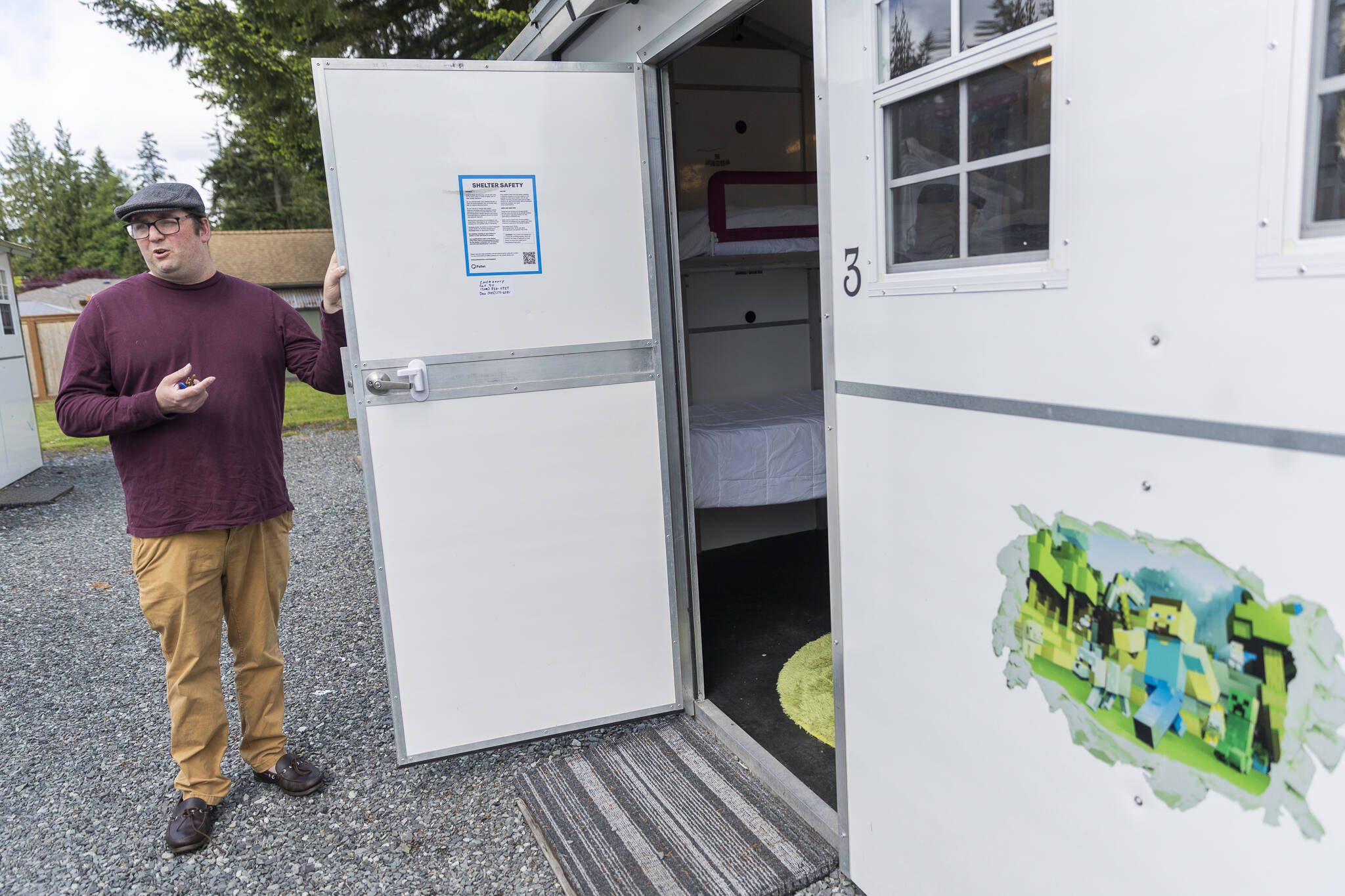 Madison Family Shelter Family Support Specialist Dan Blizard talks about one of the Pallet homes on Monday, May 19, 2025 in Everett, Washington. (Olivia Vanni / The Herald)