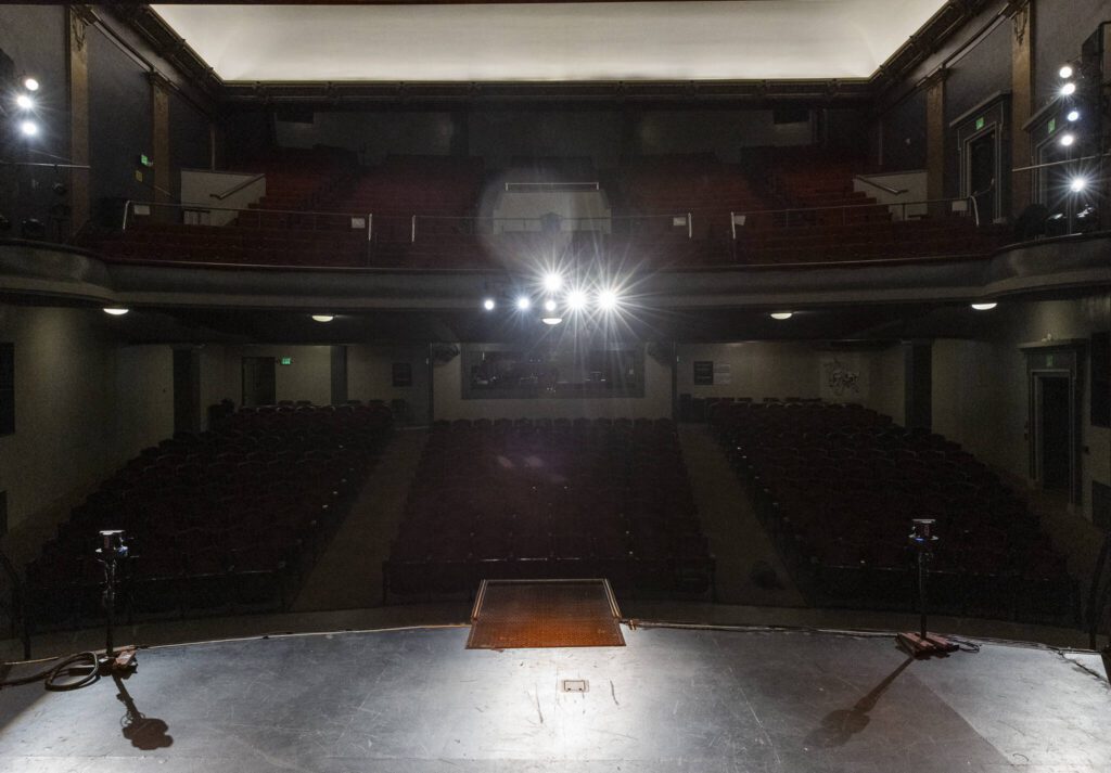 Stage lights illuminate the stage and cast a shadow over the seats at the Everett Historic Theatre, on Tuesday, May 13, 2025 in Everett, Washington. (Olivia Vanni / The Herald)
