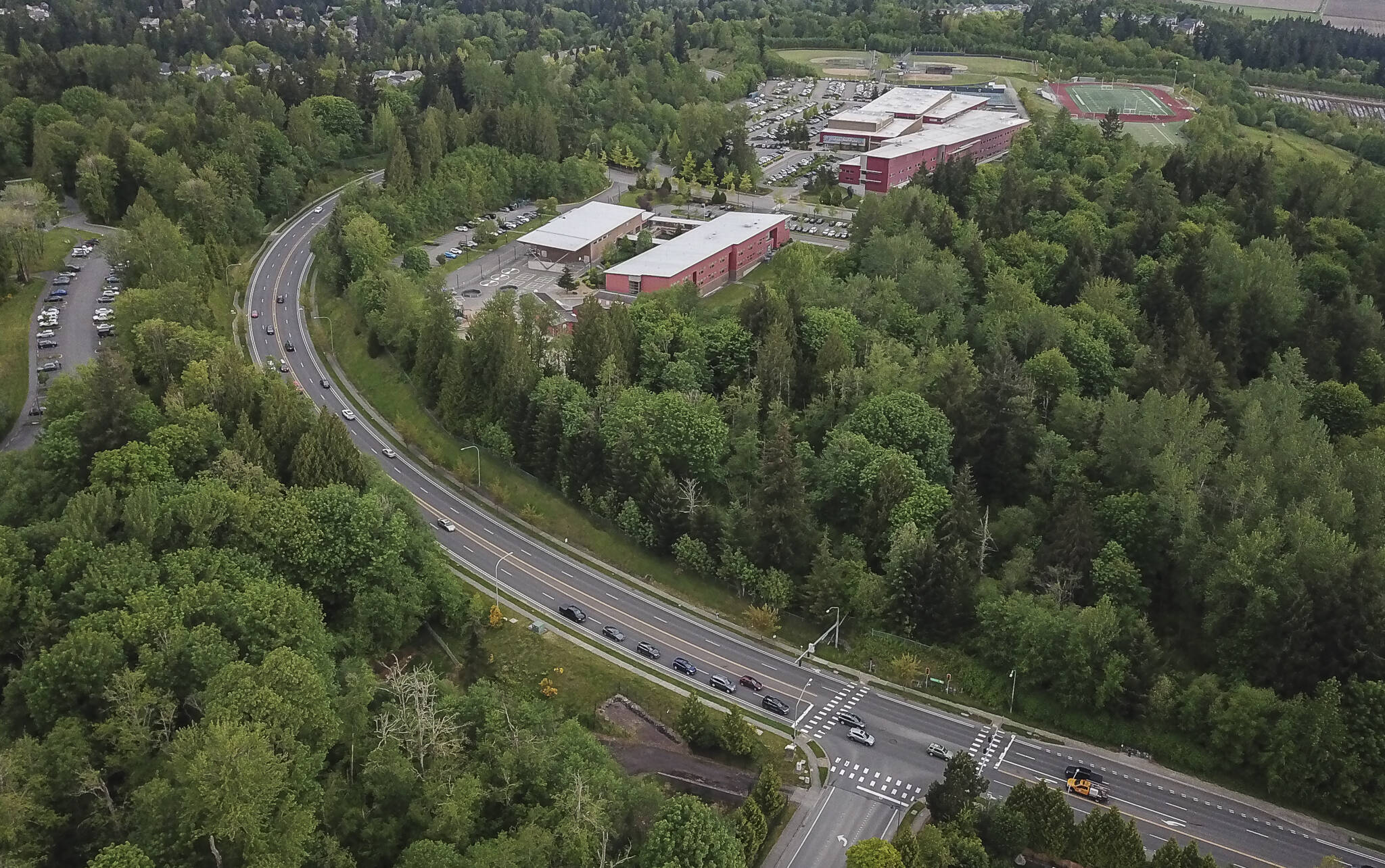 Cars drive along Cathcart Way next to the site of the proposed Eastview Village development that borders Little Cedars Elementary on Wednesday, May 7, 2025 in Everett, Washington. (Olivia Vanni / The Herald)