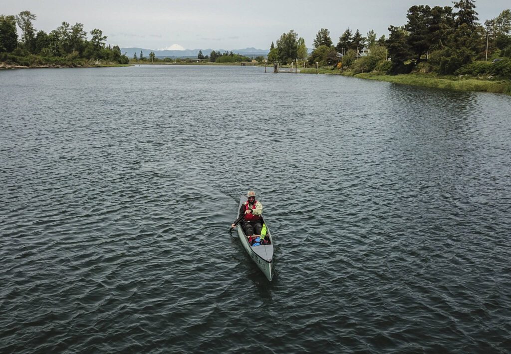 Kyle Parker paddles his canoe along the Snohomish River next to Langus Riverfront Park on Thursday, May 8, 2025 in Everett, Washington. (Olivia Vanni / The Herald)
