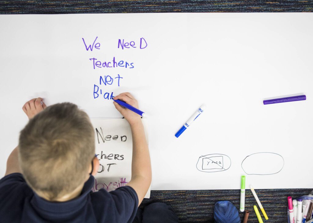 Kids write down their thoughts of the proposed closing of the Early Learning Center on Tuesday, Nov. 30, 2021 in Everett, Wa. (Olivia Vanni / The Herald)
