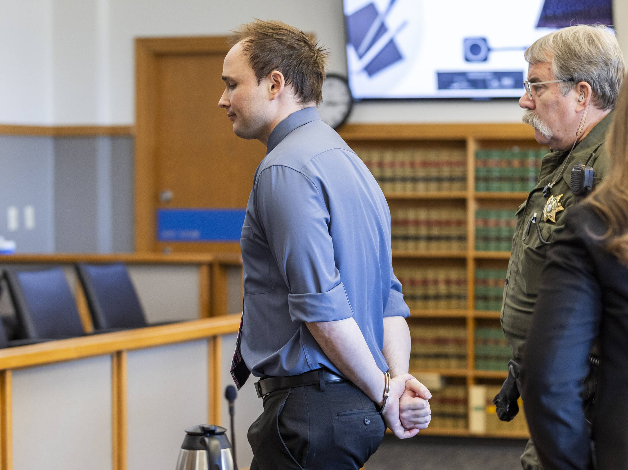 Christian Sayre walks out of the courtroom in handcuffs after being found guilty on two counts of indecent liberties at the end of his trial at the Snohomish County Courthouse on Monday, May 12, 2025 in Everett, Washington. (Olivia Vanni / The Herald)