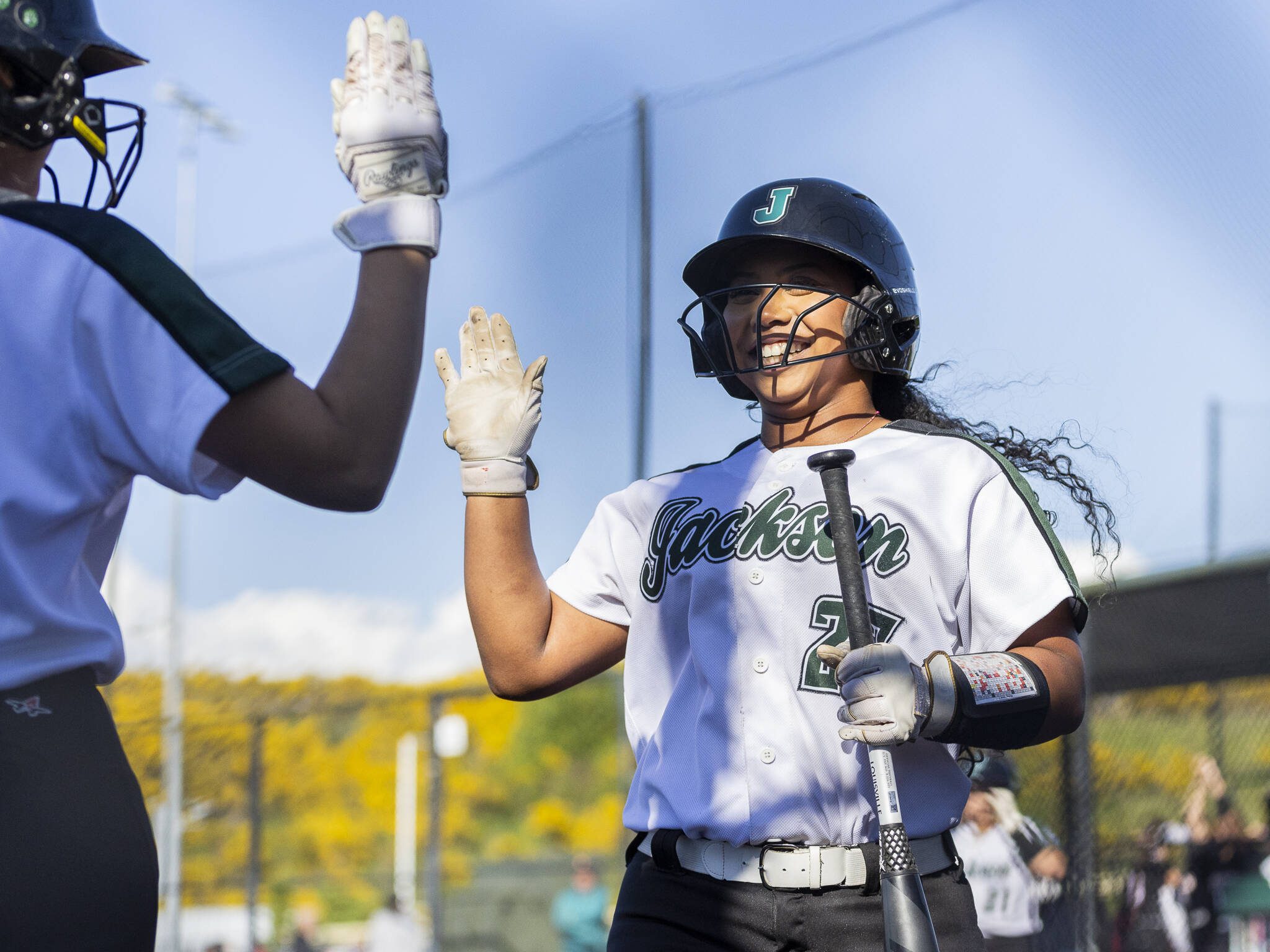 Jackson’s Elena Eigner high fives her teammate after scoring during the game on Monday, May 12, 2025 in Everett, Washington. (Olivia Vanni / The Herald)