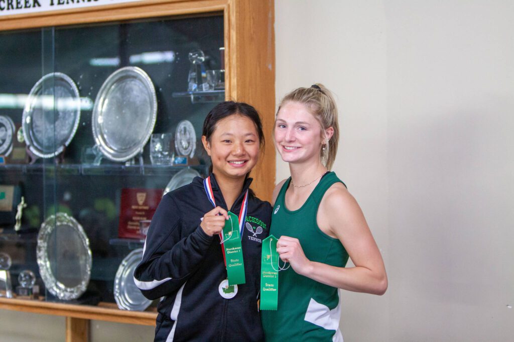 Jackson’s Jasmine Wijaya (left) and Gracie Schouten (right) pose for a photo after their District 1 4A singles championship match on May 14, 2025 at Mill Creek Tennis Club. (Qasim Ali / The Herald)
