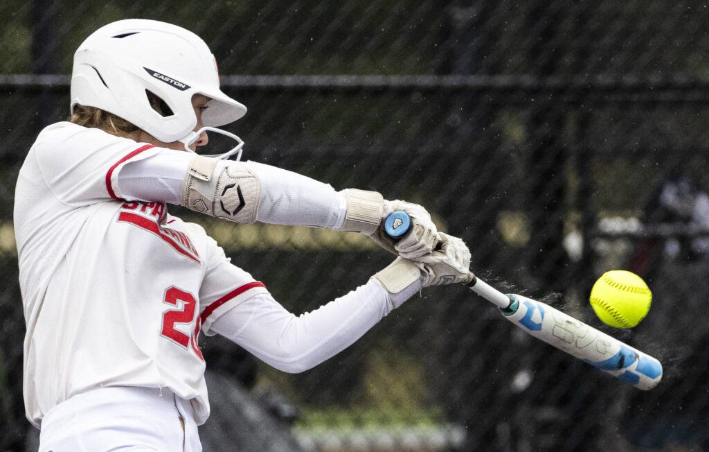 Water flies off of Stanwood’s Reagan Ryan as she gets a hit during the 3A District 1 championship game against Sedro-Woolley on Thursday, May 15, 2025 in Everett, Washington. (Olivia Vanni / The Herald)
