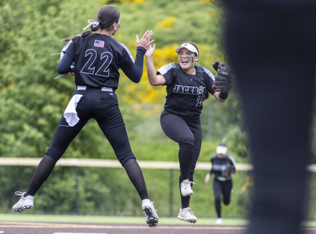 Jackson’s Matea Lopez and Allie Thomsen leap in the air and high five during the 4A District 1 game against Lake Stevens on Friday, May 16, 2025 in Everett, Washington. (Olivia Vanni / The Herald)
