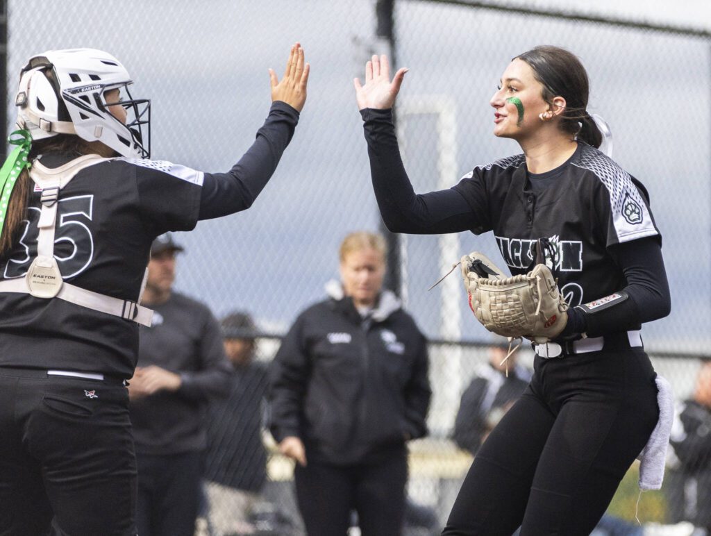 Jackson’s Allie Thomsen high-fives Madison Jacquot during the 4A District 1 game against Lake Stevens on Friday, May 16, 2025 in Everett, Washington. (Olivia Vanni / The Herald)
