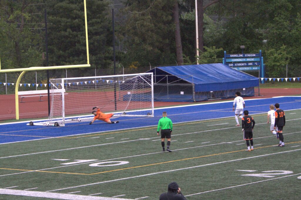 Shorewood’s Matthew Bereket (7) pushes a penalty shot past Monroe goalkeeper Pedro Gaspar during the District 1 3A boys soccer championship game on May 17, 2025 at Shoreline Stadium. (Qasim Ali / The Herald)
