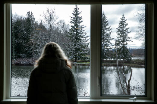 A visitor takes in the view of Twin Lakes from a second floor unit at Housing Hope’s Twin Lakes Landing II Wednesday, Feb. 22, 2023, in Marysville, Washington. (Ryan Berry / The Herald)