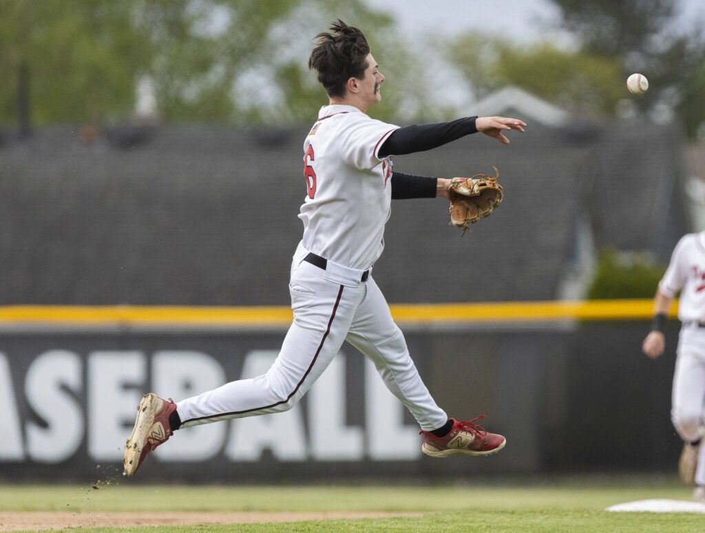 Snohomish’s Reve LeRoux leaps in the air while making a throw to first base during the opening round 3A state game against Bellevue on Tuesday, May 20, 2025 in Snohomish, Washington. (Olivia Vanni / The Herald)
