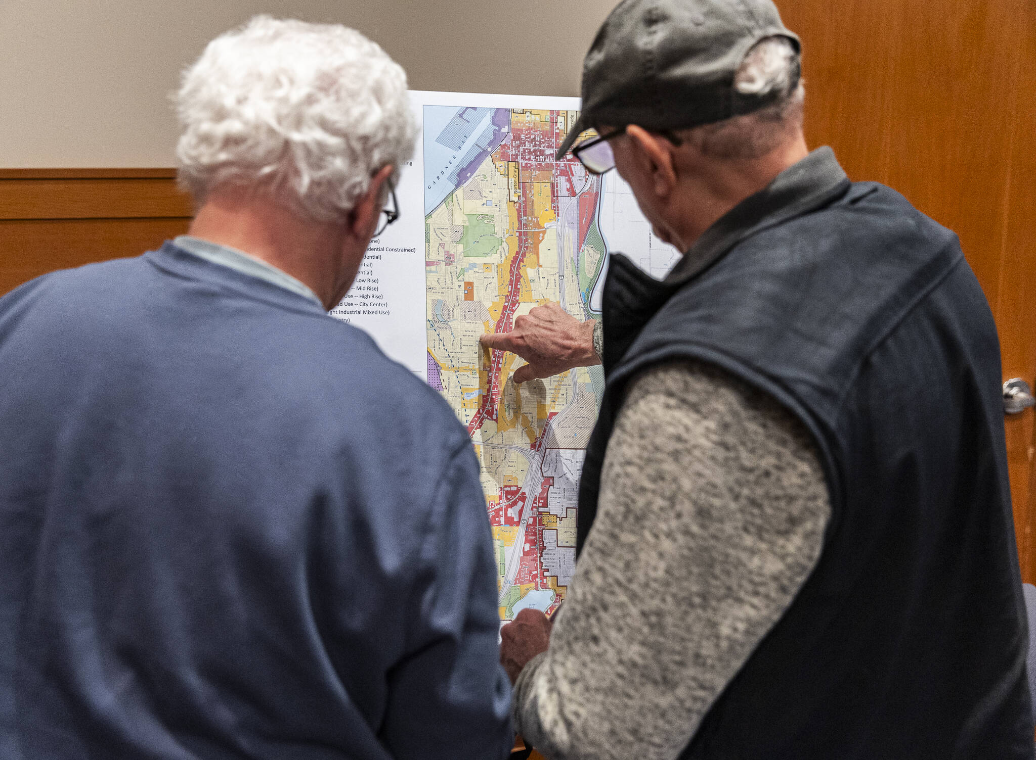 Pat Cronin and Jamie Lyon look over a zoning district map draft of Everett on display during an Everett Planning Department open house at Everett Station on Wednesday, Feb. 26, 2025 in Everett, Washington. (Olivia Vanni / The Herald)