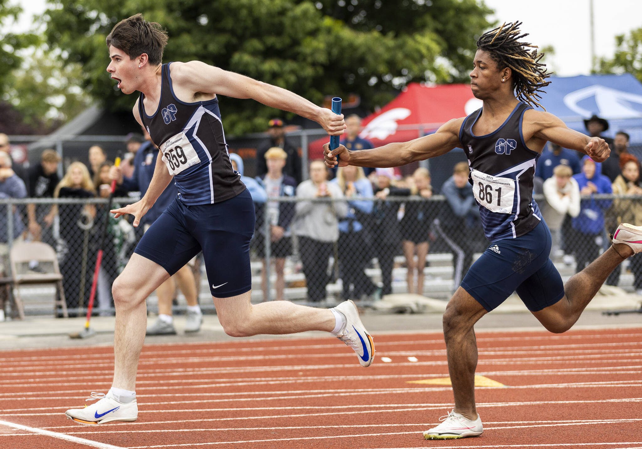 Glacier Peak’s Mateo Ganje, left, receives the baton from Isaiah Owens in the 4A boys 4x100 relay final on Saturday, May 31, 2025 in Tacoma, Washington. (Olivia Vanni / The Herald)